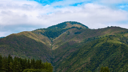 Naklejka premium hills under blue sky and clouds