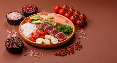 Seafood bowl, tuna tataki fillet slices with rice, oranges, tomatoes and sauce. Tuna bowl