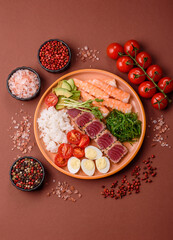 Seafood bowl, tuna tataki fillet slices with rice, oranges, tomatoes and sauce. Tuna bowl