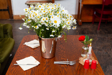 Elegant table with daisies and candle