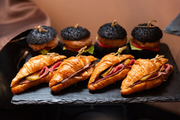 Gourmet croissants and black burgers display