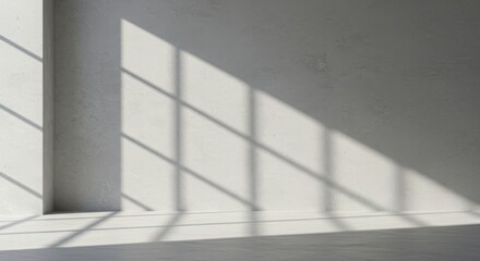 Obraz premium Sunlight casting geometric shadow patterns across a plain, lightcolored wall and floor, creating a minimalist and serene interior background