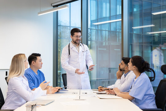 Healthcare professionals gather in a modern workspace to discuss medical cases, strategies, and treatments. Collaborative teamwork is emphasized, showcasing the importance of communication - Powered by Adobe