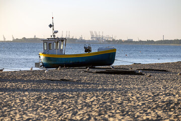 Fototapeta premium Kuter rybacki na plaży o zachodzie słońca