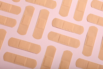 Adhesive bandage plaster on on a coloured background, the concept of protection