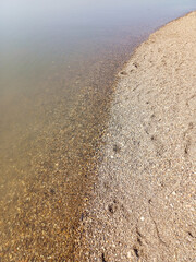Smooth pebbles lining the shore where they meet clear river water