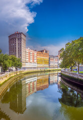 The calm waters of the Nervion river acts as a mirror for interesting skyline of the city of Bilbao, Biscay, Basque Country, northern Spain