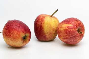 Three wet apples on a white background