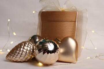 A festive wooden gift box with golden Christmas toys and warm garlands is the perfect photo for...