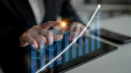 A business professional interacts with a tablet, showcasing a dynamic financial growth chart, representative of strategic analysis and investment success. Impute