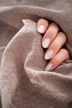 Beautiful women's manicure of milky color with silver stripes. Autumn design