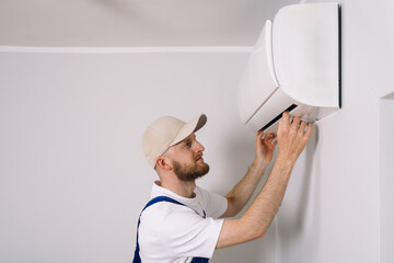 Fototapeta na wymiar Maintenance technician performs air conditioning installation in a modern apartment