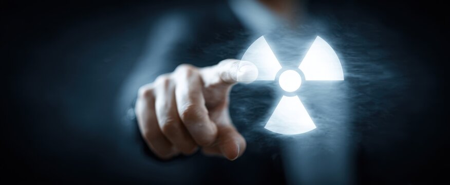 The Radiation Symbol Touched by a Hand Over a Futuristic Digital Interface - Powered by Adobe