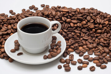 Cup of aromatic coffee and coffee beans on a white background