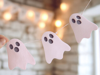 String of pink paper ghost cutouts for DIY Halloween decor—ideal for craft tutorials, seasonal party inspiration, or festive home styling ideas.