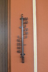 Thermometer in Celsius on the house wall on hot sunny summer day in Crete Greece