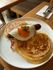 Pancake with sausage and sunny side up eggs for breakfast at restaurant