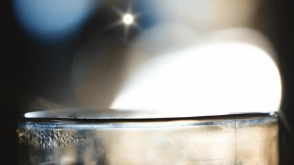 Abstract close-up of a brilliant light source reflecting on a metallic surface with a starburst lens flare and soft bokeh background - Powered by Adobe