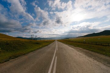 Scenic open road in countryside with dramatic clouds and vast landscape
