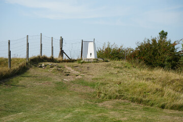 Crich Memorial Tower, England - August 13 2025: Hilltop trig point and fence landscape on a sunny day near Crich Memorial Tower in England