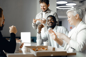 Diverse Corporate Team Enjoying a Casual Office Lunch with Pizza and Coffee