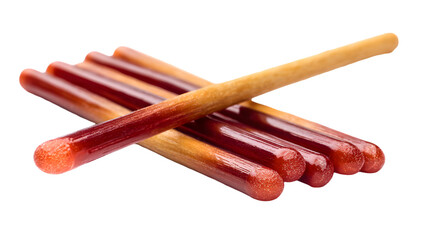 A close up of several pocky sticks with chocolate covered ends laying on a black surface in a pile