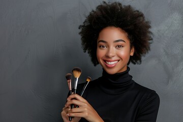 Black woman with afro hairstyle, Holding makeup brushes, Studio portrait on gray background, Confident beauty artist pose, Minimal backdrop, Copy space for text
