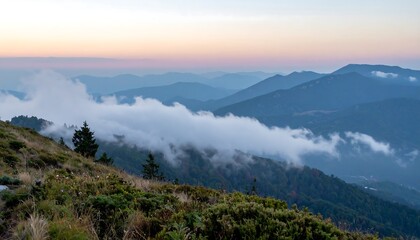 Fototapeta premium Peaceful mountain landscape with mist rolling over ridges at dawn