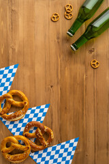 Rustic vertical wood table featuring pretzels and beer bottles, evoking a festive Oktoberfest atmosphere, flatlay, above view
