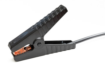 Single black jumper clip isolated on white. Automotive booster clamp with textured grip surface