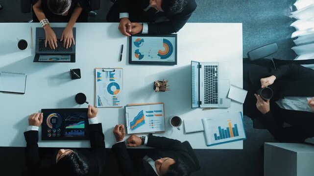 Top down aerial view of smart boss invites project manager to explain about marketing plan at white board. Group of diverse investor listen presentation while working and analyze chart. Directorate.