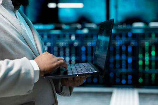 Close up of admin programming in AI data center housing advanced equipment used for machine learning training. Data scientist running code to upgrade artificial intelligence tech - Powered by Adobe