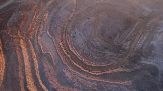 Aerial view landscape of Open pit mine with big truck, extractive industry for ore and coal at sunrise.