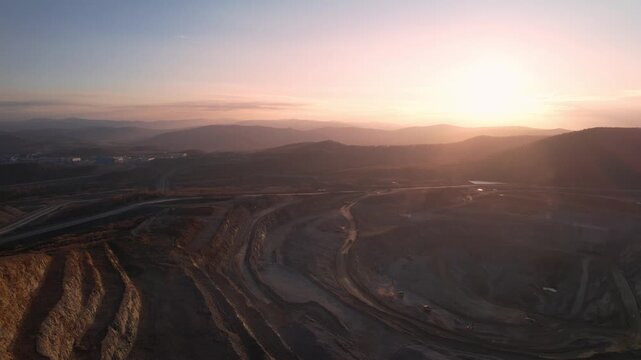 Aerial view Open pit mine with big truck, extractive industry for ore and coal at sunrise.