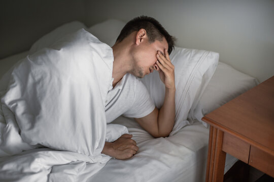 Man getting bad sleep waking up tired feeling burnt out exhausted 