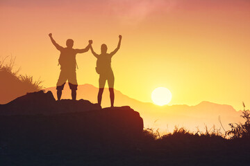 Man and woman on a mountain feeling happy, motivated facing sunset sky, couple unity support, help each other, relationship life goals 	
