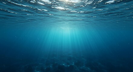 Obraz premium Stunning underwater perspective with brilliant sunlight rays illuminating deep blue ocean water, serene marine environment