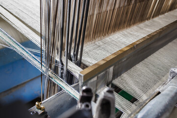 Warp and reed on modern weaving loom producing wool fabric