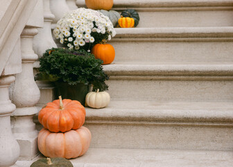 Seasonal decorations adorn steps with pumpkins, flowers, and greenery in a cozy autumn setting