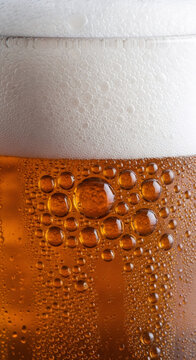 Close-up view of a glass filled with frothy beer, displaying bubbles and a rich amber hue, creating a refreshing and inviting ambiance perfect for social gatherings	