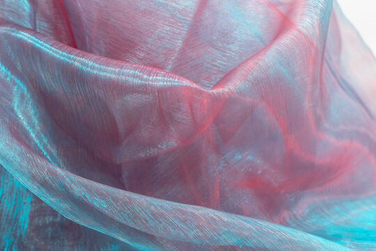 Flowing folds of translucent organza in red and blue tones, softly draped to create a romantic and elegant texture, ideal for fashion design, wedding themes, and artistic visual concepts