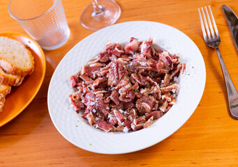 Pieces of pickled and boiled pork ears perfectly complement glass of dark beer. Authentic snack is served in pub