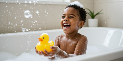 Laughing black boy playing with a rubber duck in a bubble bath. Happy child having fun in the bathtub.