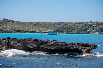 Boat trip and view on coastline of Favignana island with shallow bays with clear turquoise water, tuff rocks, abandoned quarries, caves, Egadi Islands near Sicily, Italy