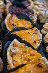 Variety of tasty French pastries, cakes, tarts, with cream and fruits on display in confectionery shop in France.