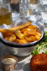 Lunch in cafe with vegetarian cheese and green asparagus croquettes served with fresh salad and french fries potato in Bruges, Belgium