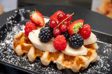 Baked belgian sugar waffles with various toppings, delicious sweet street food in Bruges, Flanders, Belgium