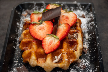 Baked belgian sugar waffles with various toppings, delicious sweet street food in Bruges, Flanders, Belgium