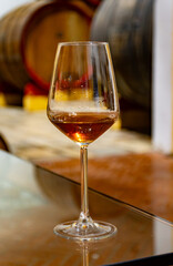 Visit of wine cellar with old large oak barrels, glass of fortified dry or sweet tasty marsala wine from barrels in Marsala, Sicily, Italy