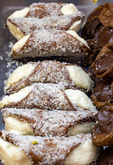 Homemade sweet pastry cannolo sfoglie filled with almond, pistachio, lemon, vanilla, chocolate cream on food market in Palermo, Sicily, Italy